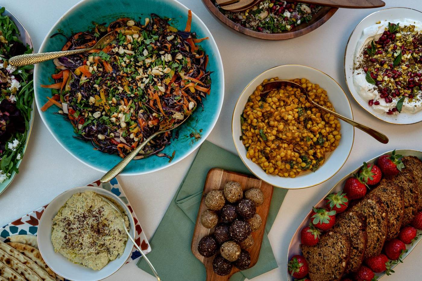 A spread of nourishing dishes including dal, salads, energy balls and yoghurt